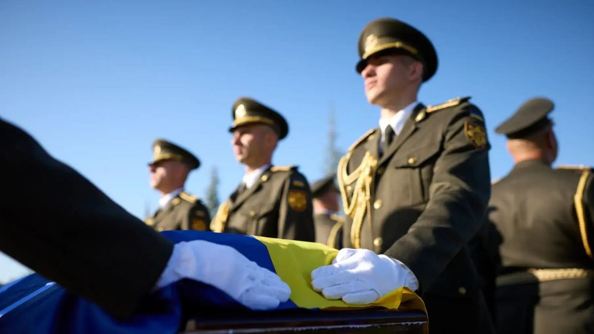 На Національному військовому кладовищі за перший місяць поховали понад 100 воїнів Військовослужбовці у парадній формі стоять біля труни, вкритої синьо-жовтим прапором