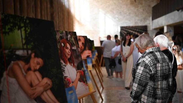 В Обухові відкрили фотовиставку «ВОНА»: історії жінок, які тримають тил зала фотовиставки, люди дивляться фотографії