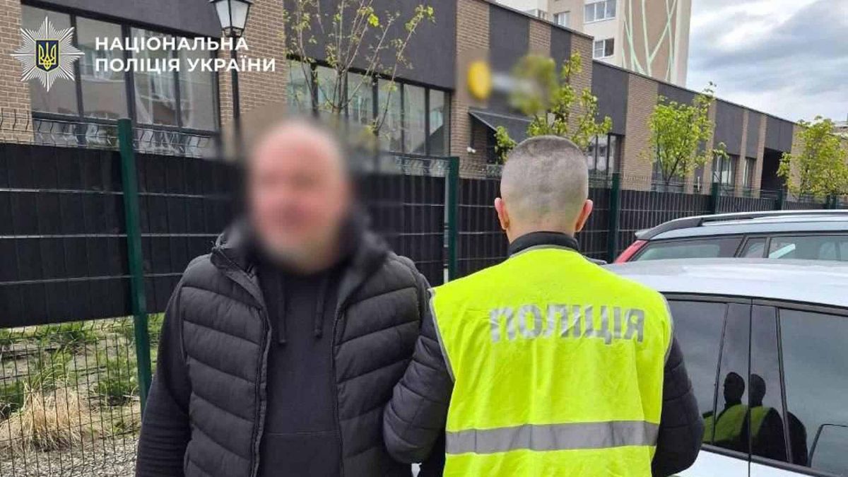 Стрілянина у Святошинському: поліція затримала 46-річного водія Поліцейський у жовтому жилеті затримує чоловіка у чорній жилетці біля автомобіля у Святошинському районі Києва