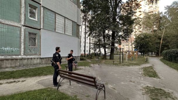 У КПІ відкрили сучасне укриття для 150 осіб у 18-му корпусі Двоє поліцейських стоять біля багатоповерхівки поруч із лавкою та дитячим майданчиком