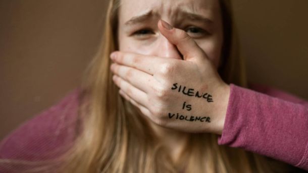 Бійка на дитячому майданчику: у Києві побили 13-річного хлопця Молода жінка закриває рот рукою, а на руці англійською мовою написано: «Мовчання – це насильство»