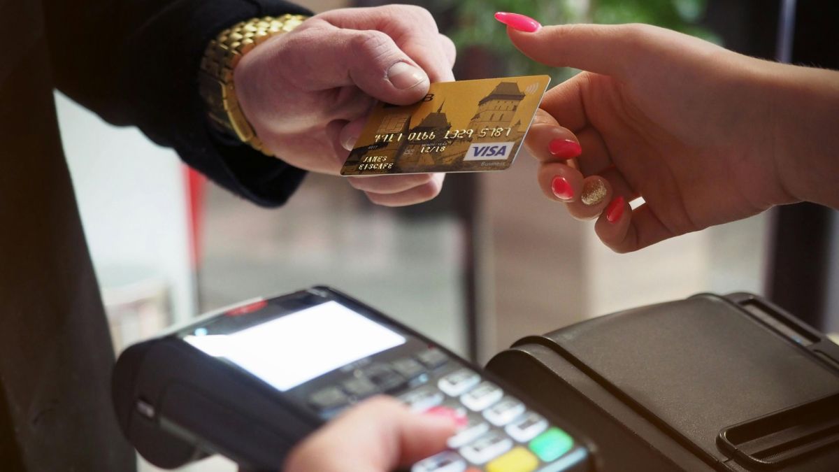 єЧек в Україні: електронний чек вже доступний у ПриватБанку та monobank Покупець передає золоту банківську картку Visa касиру для оплати через платіжний термінал у магазині