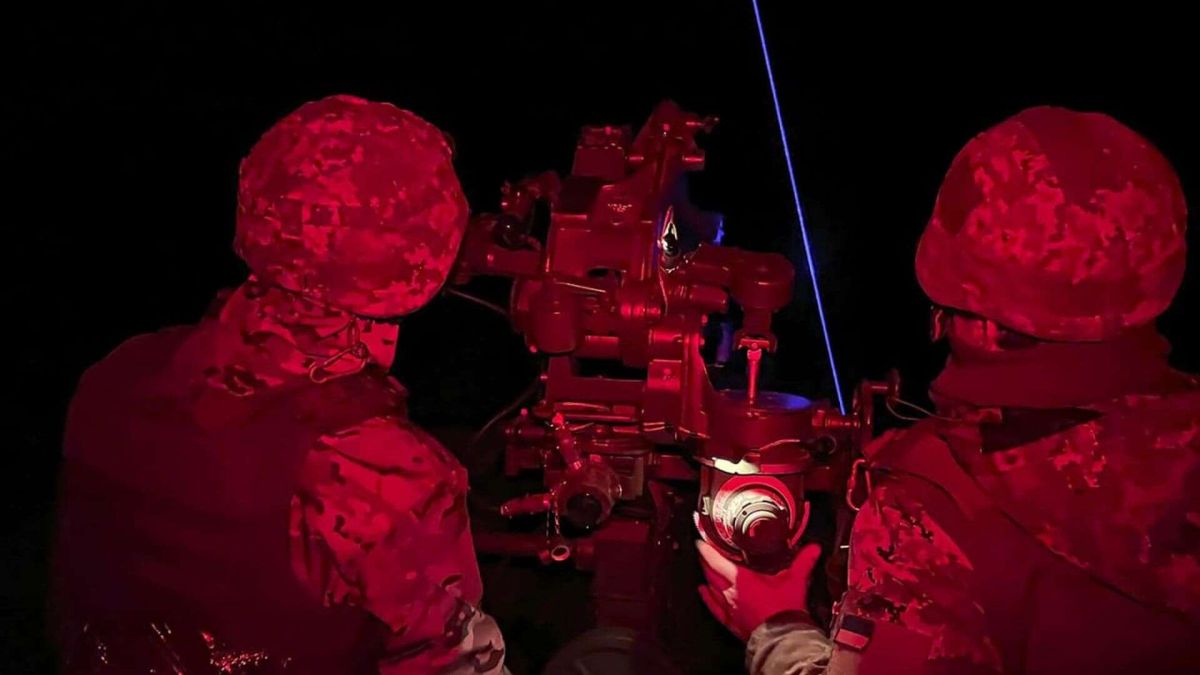 Нічна атака дронами на Київщину: пошкоджено підприємство і будинки Двоє українських військових у червоному освітленні працюють біля зенітної установки вночі