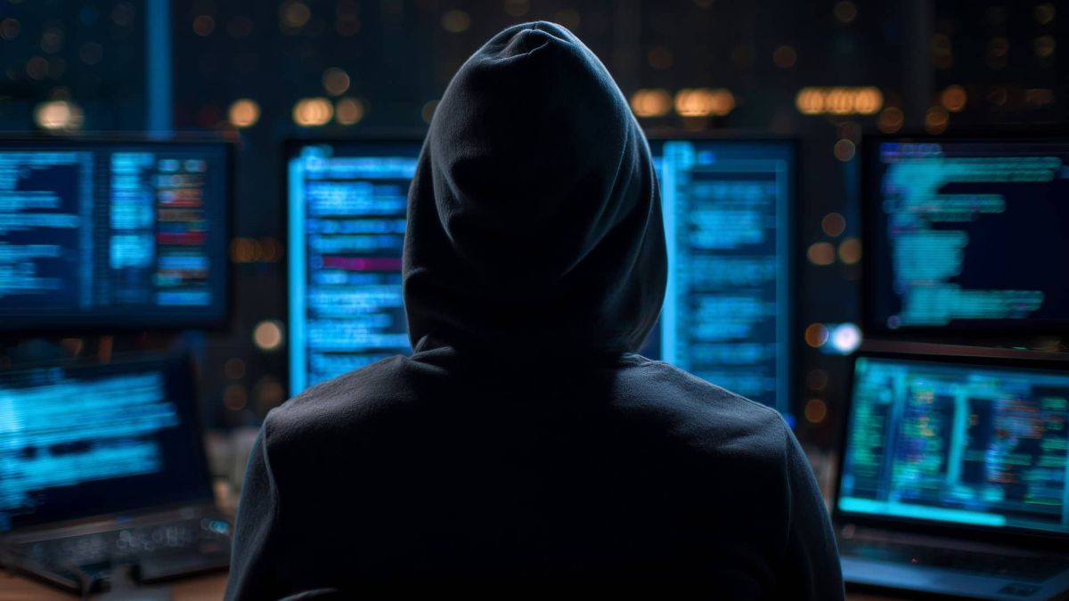 DDoS-атака на дата-центри України: збої тривають з 26 квітня Хакер у чорному худі сидить перед кількома моніторами з кодом — ілюстрація до кібератаки на дата-центри України у квітні 2026 року