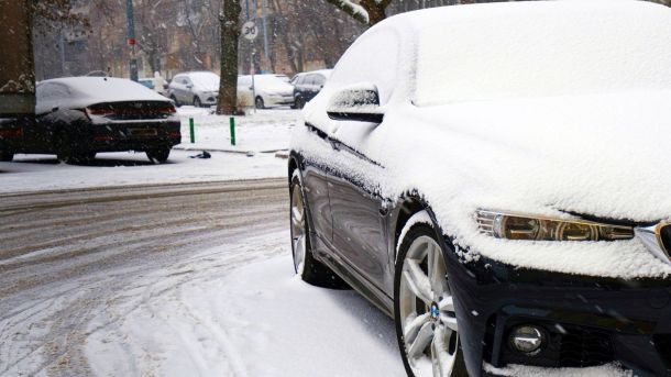 У Києві 258 одиниць техніки прибирають сніг Припарковані автомобілі, повністю вкриті снігом після рясного снігопаду, засніжена вулиця та тротуар