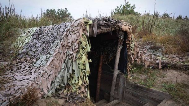 Київщина: ДТП на трасі Київ — Чоп ускладнила рух біля села Мрія (карта) Військовий бункер з камуфляжною сіткою, частково занурений у землю серед трави