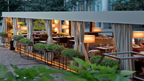 У Києві запрацювали 70 поштоматів Укрпошти: цілодобово і без доплат Літній майданчик біля кафе у Києві з столиками та стільцями просто неба на міській вулиці