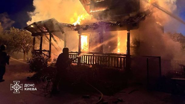 Атака на Київ 4 квітня: пожежа у Дарницькому р-ні на даху будівлі Рятувальник ДСНС гасить охоплений вогнем приватний будинок у Києві після нічного російського обстрілу 2 червня 2026 року