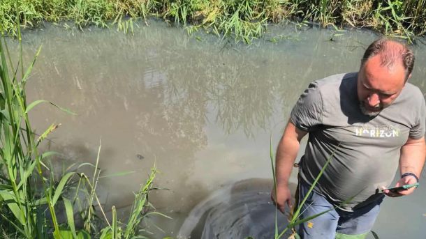 Чому на озерах Кирилівське та Йорданське заборонили купатися Чоловік у болотних чоботах стоїть по коліна у забрудненій нафтопродуктами воді озера Кирилівського на тлі очерету, фотографує на телефон
