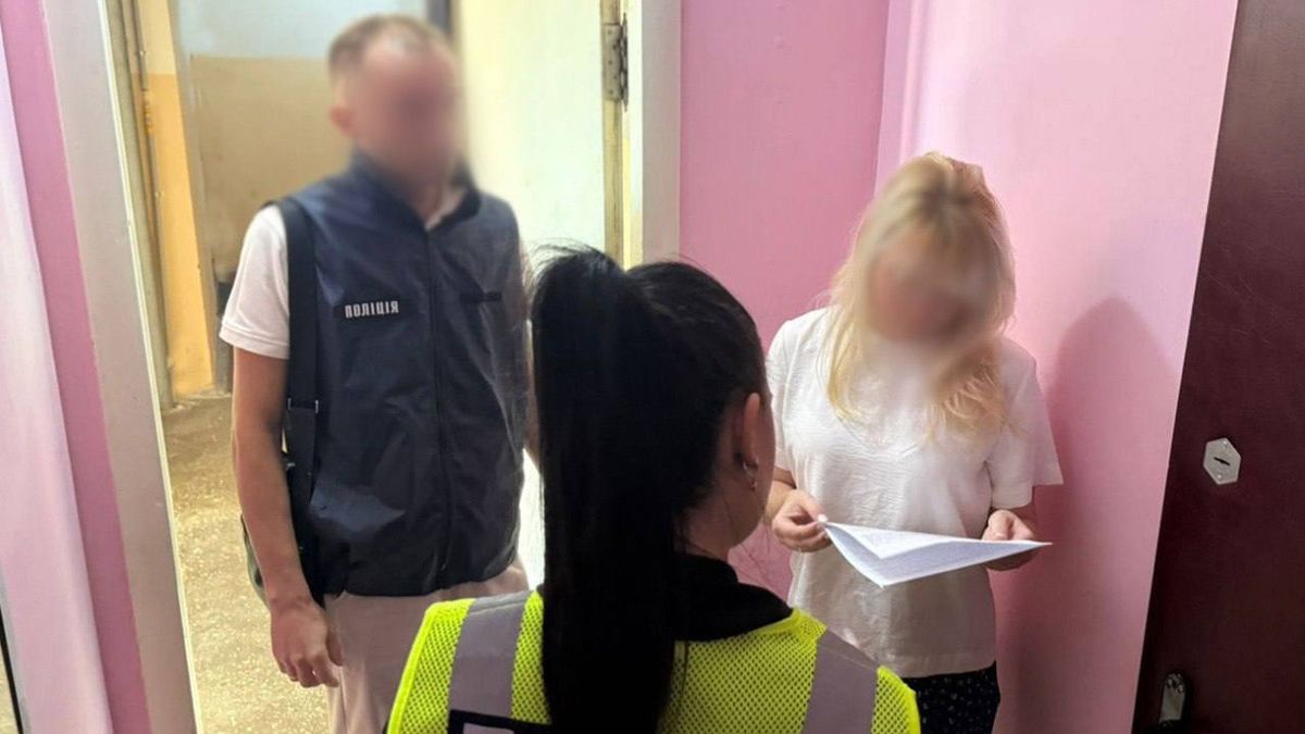 Переплата 850 тисяч грн: посадовицю Святошинської РДА підозрюють у зловживанні Перевірка документів у поліції біля житлового будинку, співробітник поліції та жінка з папером в руках, інцидент у Києві, новини міста Київ.