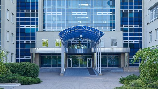 На Подолі забудовник ігнорує заборону та проводить роботи в Будинку з хлібною лавкою Сучасна будівля з великими скляними вікнами та синім навісом над входом