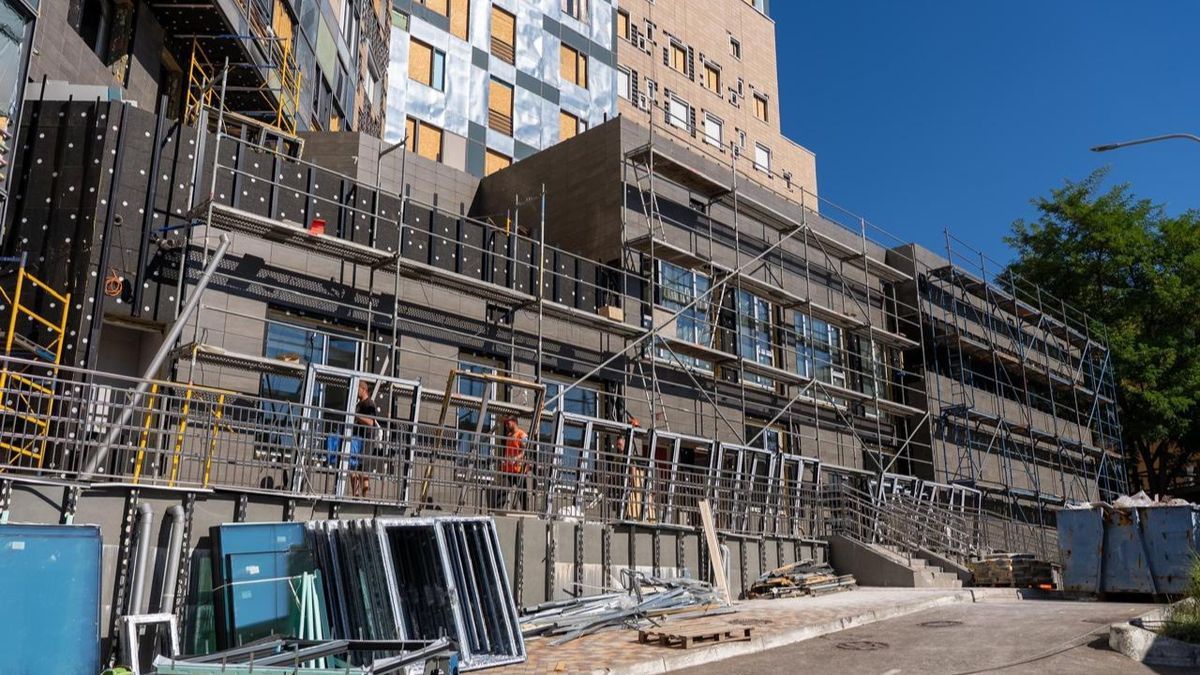 У Києві триває відновлення «Охматдиту»: фасадні та внутрішні роботи На знімку будівельні роботи на сучасному житловому комплексі у Києві, активна підготовка до завершення будівництва.