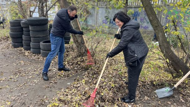 ТРЦ Retroville скасовує безплатне паркування: мешканці «Варшавського» обурені Двоє людей прибирають листя на вулиці