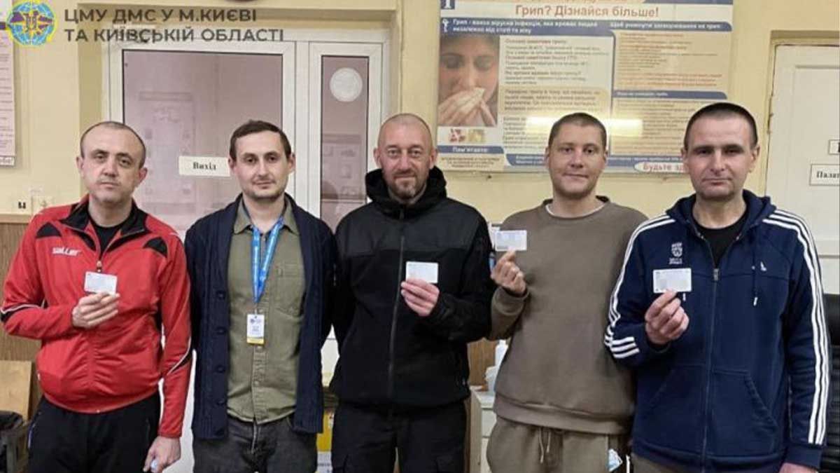 Київські захисники після полону швидко отримали нові паспорти чоловіки тримають у руці паспорта