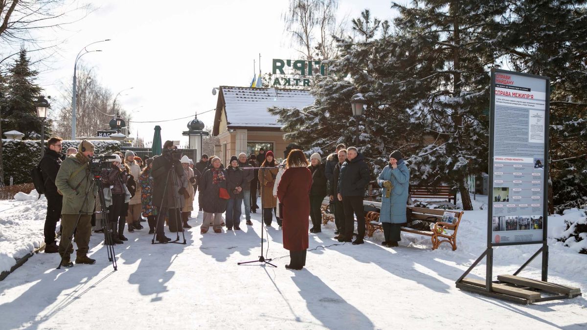 У Межигір'ї відкрилась виставка «Справи Майдану» про 585 підозрюваних Жінка виступає біля мікрофону на відкритті виставки «Справи Майдану» у Межигір'ї, натовп гостей і журналістів біля стенду з матеріалами справи
