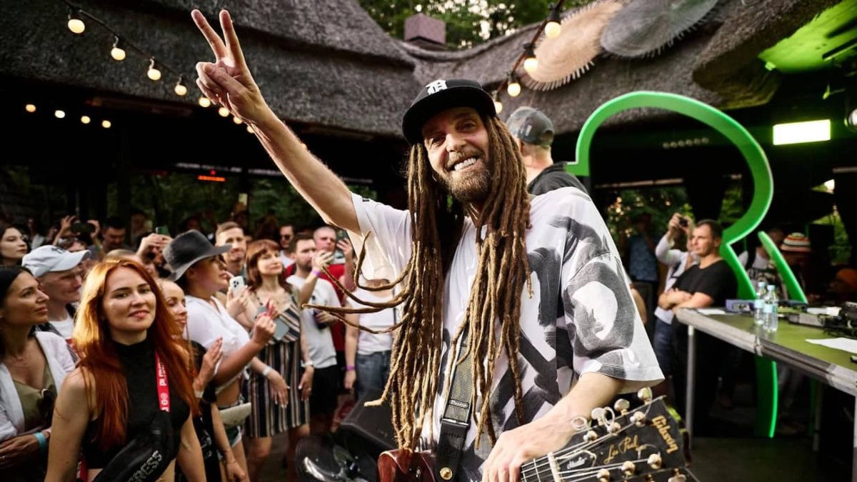 У Києві прощаються з Андрієм «Дизелем» Яценком із Green Grey (фото) Концертне фото музиканта Дизеля з гітарою, який усміхається і показує знак миру