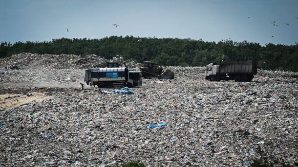 У Київській області пройшов молодіжний вишкіл «Синергія активних» — патріотизм, тактика й єдність Захаращена територія зі сміттям і вантажівками на тлі зелених дерев, зображення екологічної проблеми у Києві.