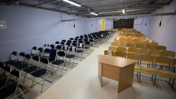 Киянин Андрій Коломієць повернувся додому після 10 років російського ув’язнення Простора кімната, переобладнана під укриття, з довгими рядами стільців