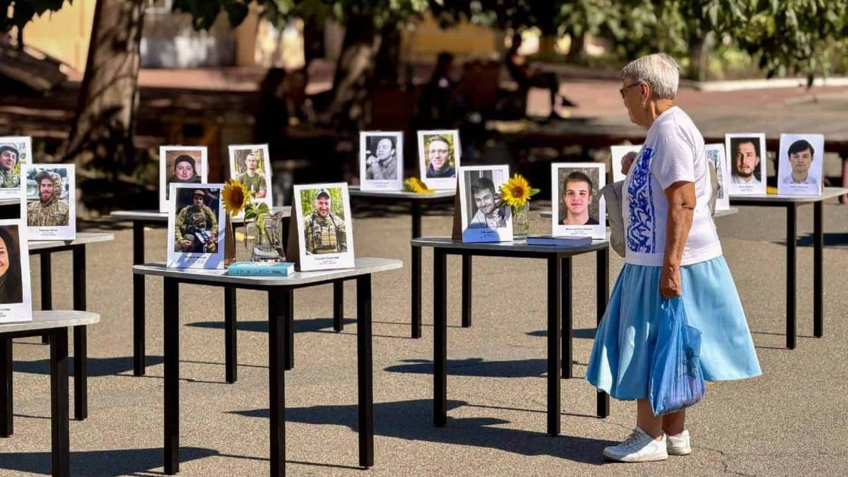 Могилянка вшанувала 36 загиблих героїв на Контрактовій площі Столи з портретами загиблих захисників, соняхами та свічками на акції «Стіл пам’яті» на Контрактовій площі, відвідувачка розглядає фотографії