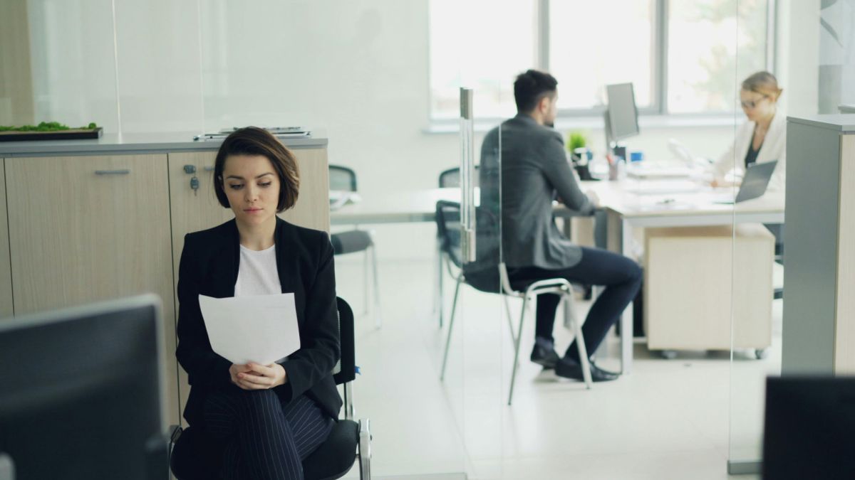 Київ посів третє місце за кількістю ФОПів-роботодавців: підприємці столиці найняли 70 тис людей Жінка в діловому костюмі сидить в офісі з документами в руках, на фоні працюють колеги за комп'ютерами
