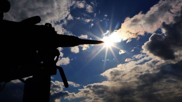 Київ: 9 рятувальників отримали нагороди за роботу під час обстрілів столиці Силует кулемета спрямований у бік сонця, яке пробивається крізь хмари на яскравому денному небі
