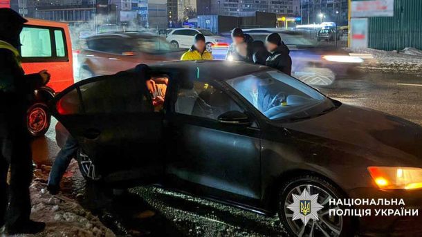 Тиждень у Києві: 8 тривог, 1200 дронів для бригади та дистанційне навчання Поліцейські затримують підозрюваного біля темного автомобіля на нічній вулиці Києва, операція Департаменту внутрішньої безпеки Нацполіції