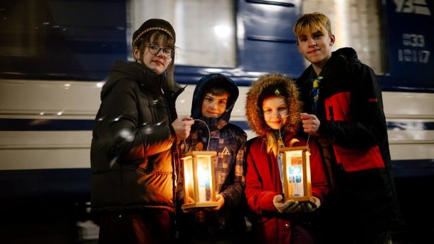 Вифлеємський вогонь вже у Києві: як символ Різдва зустріли на вокзалі Діти тримають Вифлеємський вогонь на пероні на вокзалі на фоні потяга