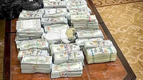 НАБУ викрило корупцію на 29 млн грн при закупівлі ПЗ для Мінсоцполітики Банкноти доларів США пофарбовані і складені у пачки, розкладені на дерев'яному столику, можливо, у приміщенні для зберігання готівки або під час операції з готівкою.