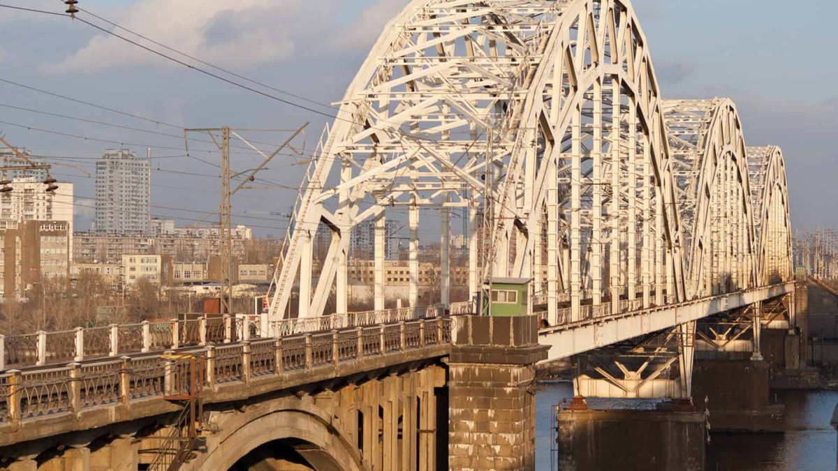 Недобудована частина Дарницького мосту належить Укрзалізниці, а не Києву Дарницький залізнично-автомобільний міст через річку Дніпро у Києві — вид на металеві ферми та арки на тлі лівобережних кварталів