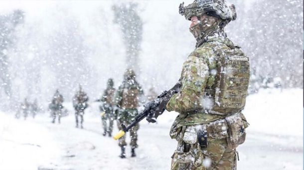 ЗСУ знищили понад 1040 окупантів за добу Українські військові у камуфляжі рухаються колоною під сильним снігопадом, на передньому плані боєць зі зброєю
