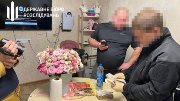 Офіцер змушував бійців готувати шаурму: ДБР відкрило справу Троє чоловіків, двоє з них працівники ДБР у кімнаті біля стола рахують гроші. Обличчя заблюрені, один з чоловіків з камерою в руках