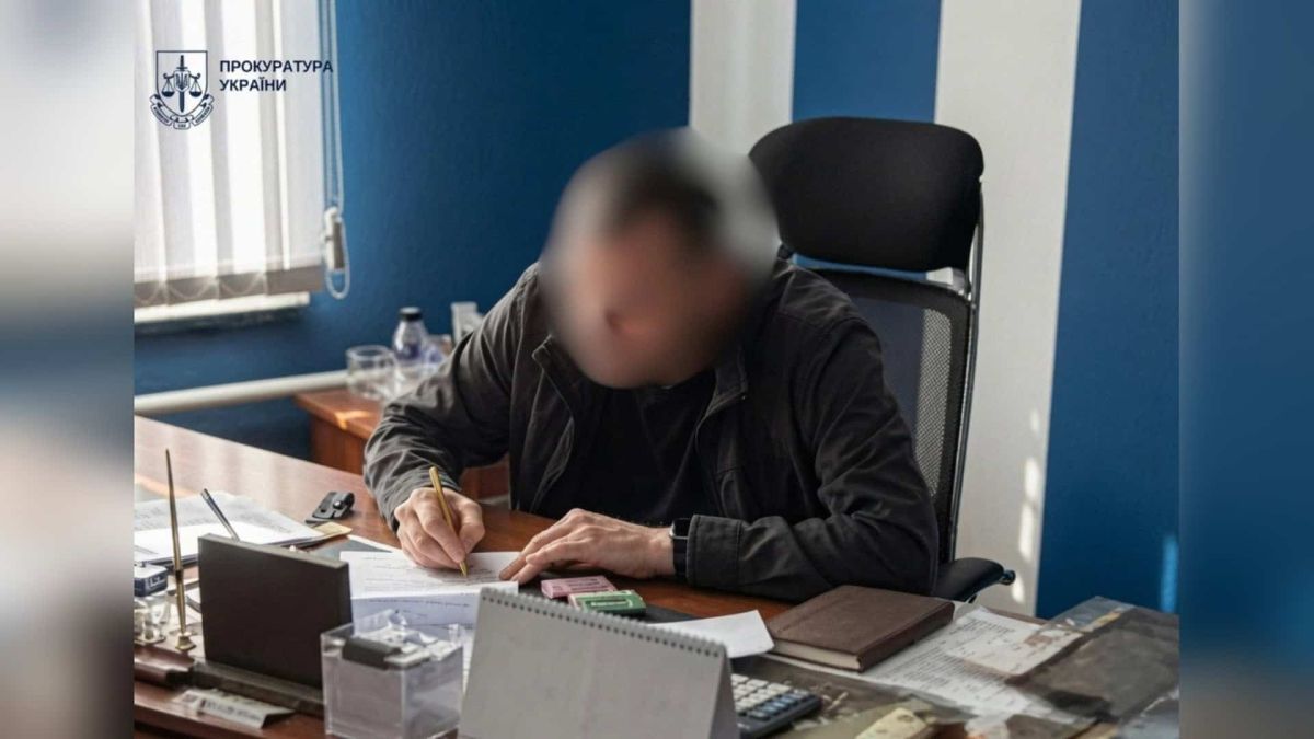 Прокуратура: керівник «Київзеленбуду» не задекларував 8,4 мільйона гривень Чоловік із розмитим обличчям заповнює документи за робочим столом у кабінеті, фото прокуратури у справі «Київзеленбуду»