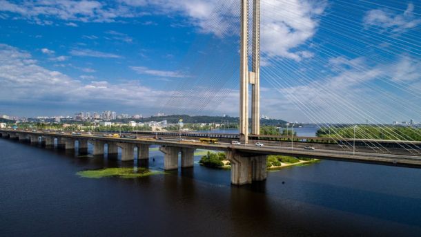 Монумент сови відкрили в сквері на Щекавицькій у Подільському р-ні Південний міст через Дніпро в Києві з висоти: вантові пілони, автомобільний рух і широка річка під мостом