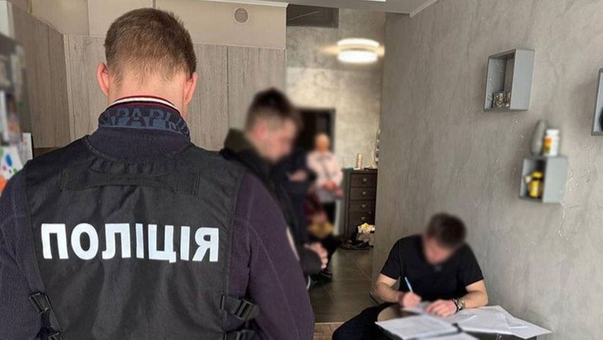 У Києві судитимуть 9 фігурантів справи про розкрадання 4,2 млн грн на ремонтах парків Обшук у квартирі, який проводять поліцейські, один із них у жилеті з написом «Поліція»