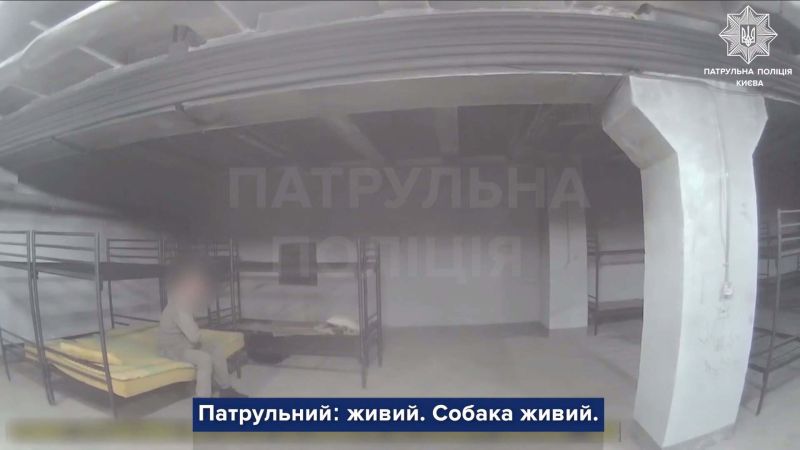 Головні новини Києва | Kyiv.News Чоловік із розмитим обличчям сидить на нарах в укритті житлового будинку, кадр відео патрульної поліції Києва із субтитрами