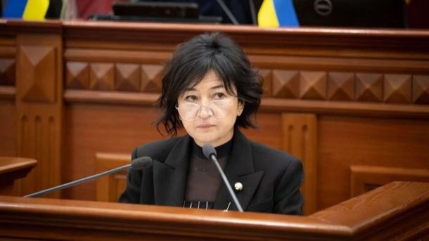 У Києві підприємця підозрюють у фіктивному працевлаштуванні іноземців за $4500 Жінка з коротким чорним волоссям у чорному піджаку та окулярах стоїть за трибуною