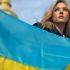 Головні новини Києва | Kyiv.News Акторка Кетрін Винник тримає синьо-жовтий прапор України на тлі золотого купола храму в Києві