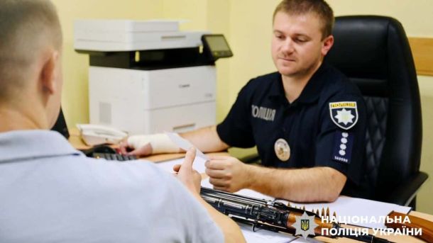 Кияни задекларували понад тисячу одиниць зброї та 300 тисяч набоїв Обличчя співробітника поліції під час прийому від громадянина в офісі, офіційна ситуація в правоохоронних органах України.