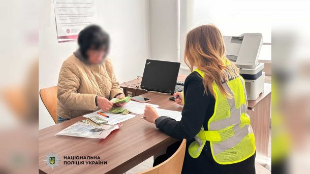 Поліція виявила наркотики у двох киян: Святошин і Солом'янка Поліцейська у жовтому жилеті документує вилучену готівку від жінки-кур'єра шахраїв у відділку поліції Києва — справа про шахрайство під виглядом СБУ