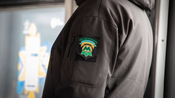Метром Києва за тиждень скористалися 4,8 млн пасажирів: ескалатори зупинили 123 рази Працівник Київського метрополітену у темній куртці з нашивкою-шевроном підприємства на рукаві, на фоні вагона метро