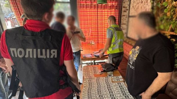 Початок кінця НАТО: коли гіпотетичний сценарій стає попередженням Поліцейські проводять обшук: на столі розкладені доларові купюри, кілька чоловіків із затертими обличчями спостерігають