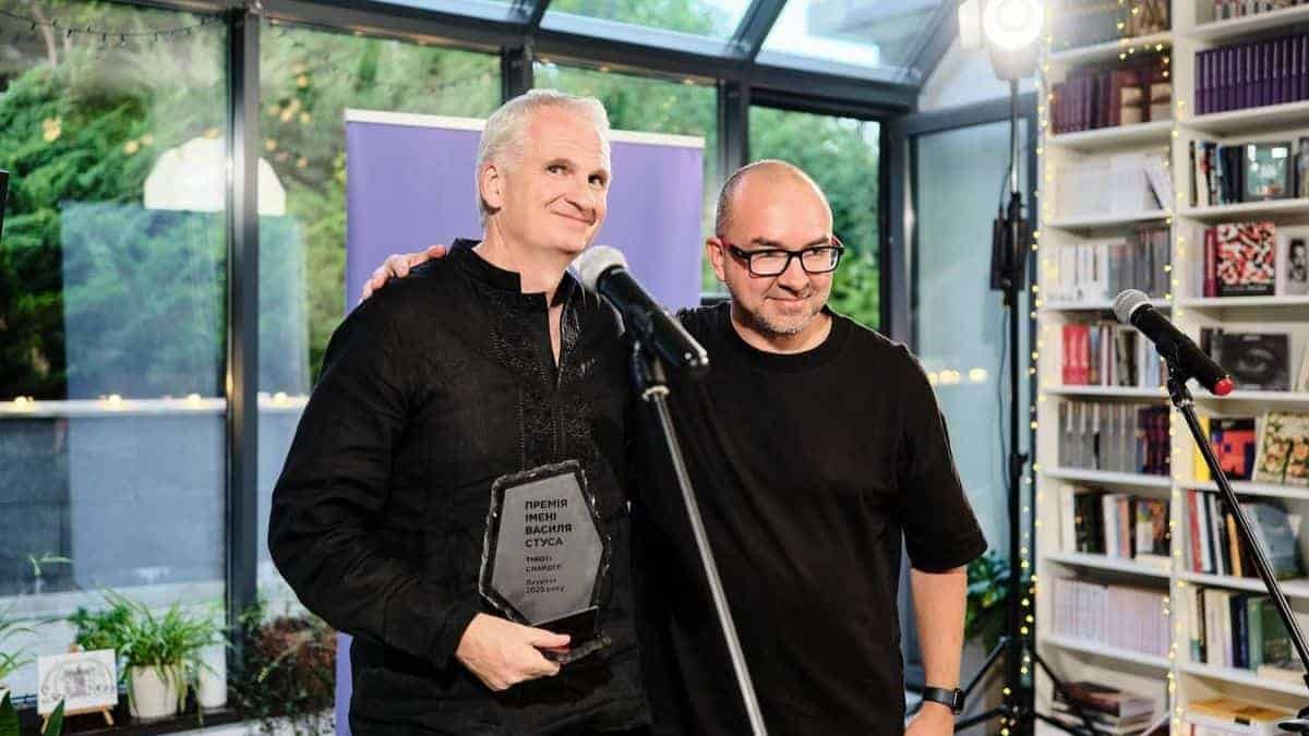Американський історик Тімоті Снайдер отримав Премію імені Василя Стуса в Києві Двоє чоловіків стоять біля мікрофона у світлому приміщенні з книжковими полицями