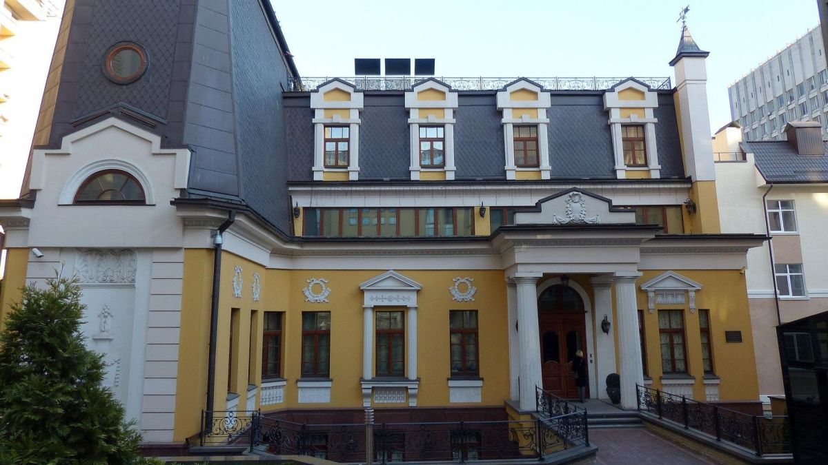 У центрі Києва за $9,5 мільйона продають історичний маєток початку 20 століття Жовтий двоповерховий будинок з білими архітектурними елементами, мансардою з чотирма вікнами