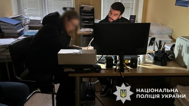 Оголошено підозру посадовиці у Деснянському районі: 1,9 млн грн переплати за світло для шкіл Підозрювана сидить за столом з представником правоохоронних органів