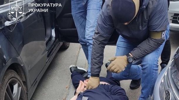 18 листопада в Україні діятимуть відключення світла до 4 черг Чоловік в масці тримає затриманого на землі за руки, які скрутили за спиною
