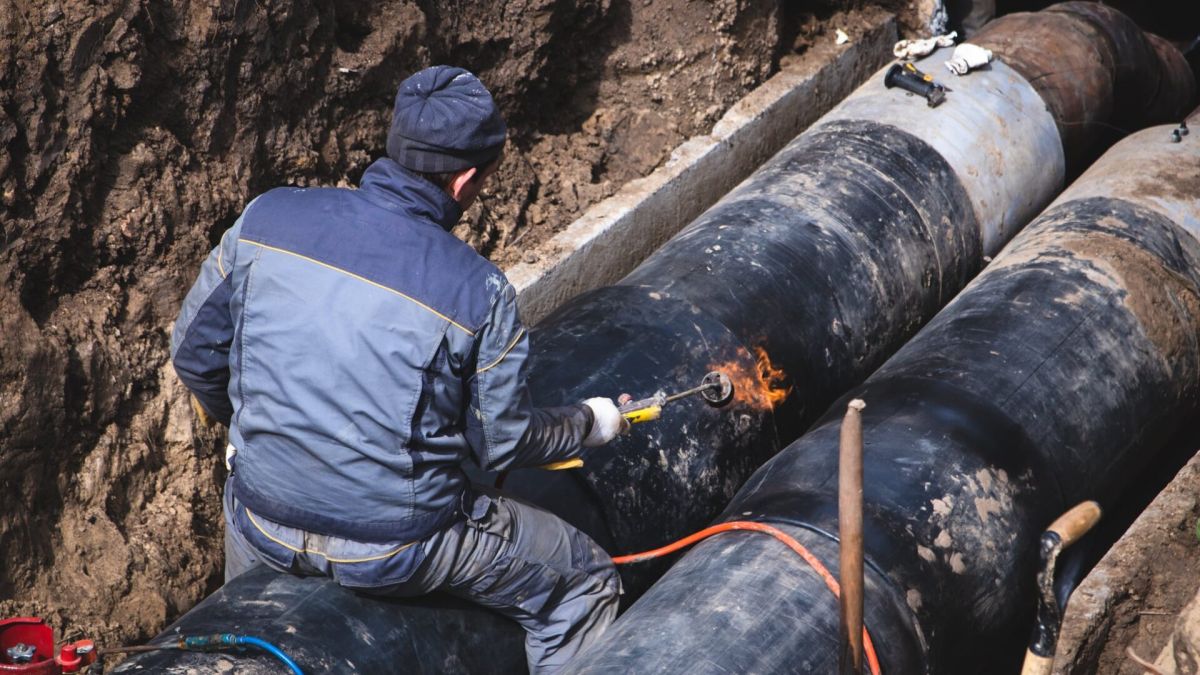 Понад 100 будинків без тепла: у Києві ремонтують пошкоджену тепломережу Робітник під час ремонту трубопроводу