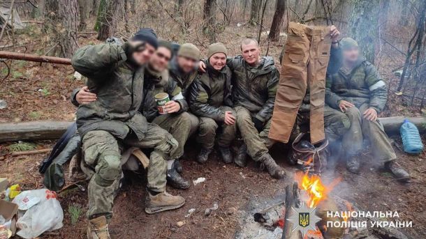 Бучанська громада отримає 300 модульних конструкцій від землі Бранденбург Російські солдати в камуфляжі сидять на колоді біля вогню в лісі