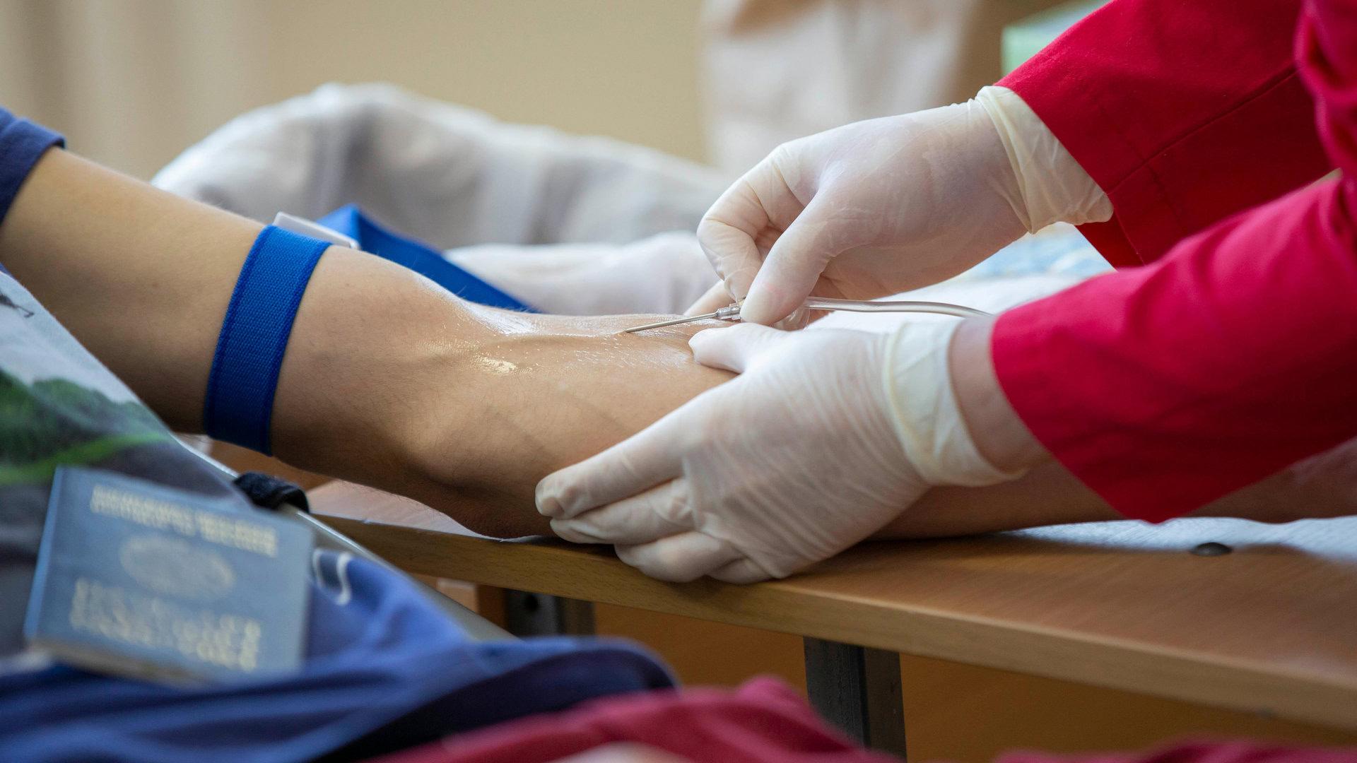 Медсестра бере кров у донора