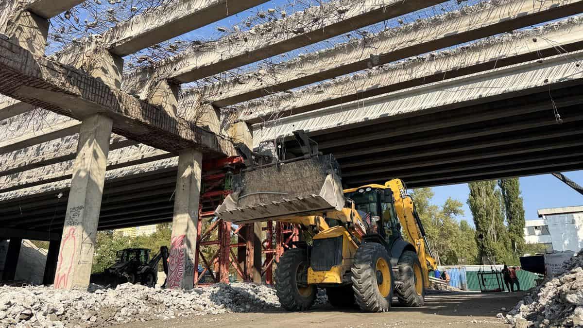 На Полярній у Києві оновлюють шляхопровід: завершили перший етап капремонту Будівельна техніка під мостом під час демонтажу бетонних балок, з яких стирчить арматура
