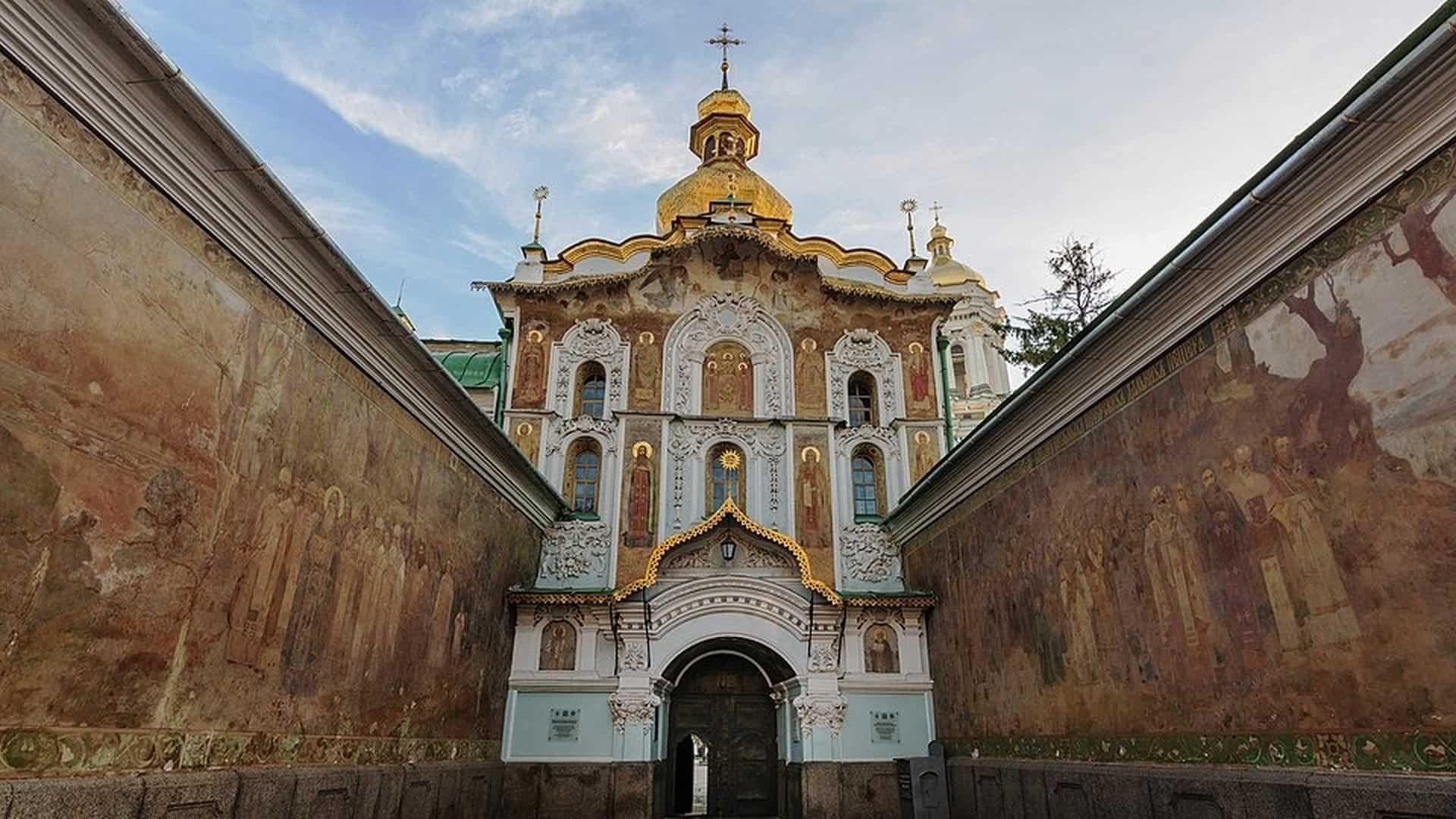 Золотоверха церква у стилі бароко, розташована між високими стінами з фресками